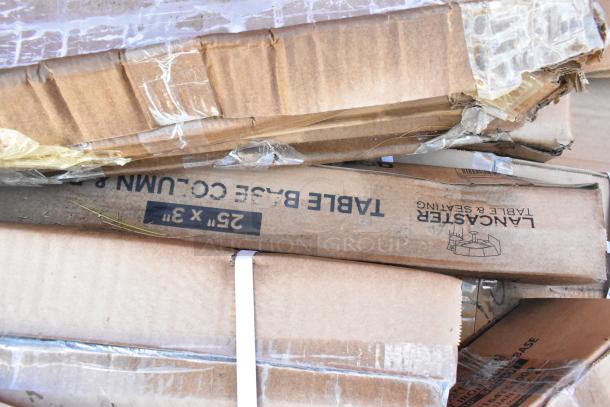 Boxes of Lancaster Table & Seating cast iron table bases, marked "25" x 3" Table Base Column." Items are new with scratch and dent packaging.