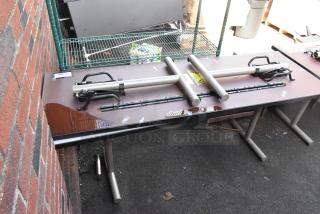 Two folding tables with metal legs, stained surface, stacked equipment, outdoor location. Tag reads "300+".