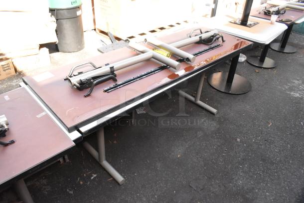 Two folding tables, metal legs, brown tops, minor wear. Includes hardware and labels indicating “2 Tables. 2 Times Your Bid.”