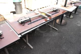 Two folding tables, metal legs, brown tops, minor wear. Includes hardware and labels indicating “2 Tables. 2 Times Your Bid.”