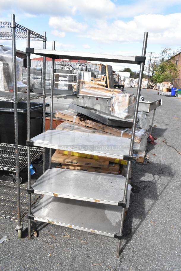Chrome finish 4 tier wire shelving unit shown outdoors, used condition. Buyer must dismantle for transport. Consider freight charges.