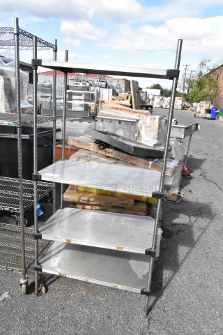 Chrome finish 4 tier wire shelving unit shown outdoors, used condition. Buyer must dismantle for transport. Consider freight charges.