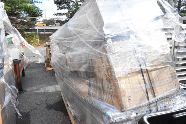 Pallet of brand new, scratch and dent stainless steel kitchen equipment wrapped in plastic, including Regency mop sink and dish cabinet.