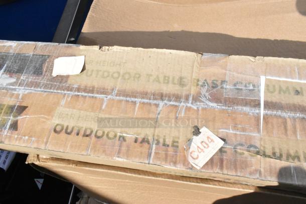 Cardboard box labeled "Outdoor Table Base Column" with visible wear and a sticker marked "C404." Item is new, scratch and dent condition.