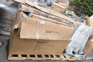 Pallet of brand new Regency and Steelton stainless steel tables and shelves, boxed with signs of minor damage.