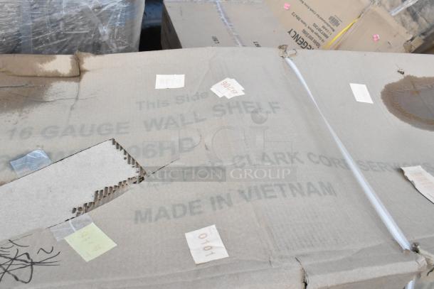 Pallet with boxed Regency stainless steel tables and shelf, labeled "16-GAUGE WALL SHELF" and "MADE IN VIETNAM," shows damage.