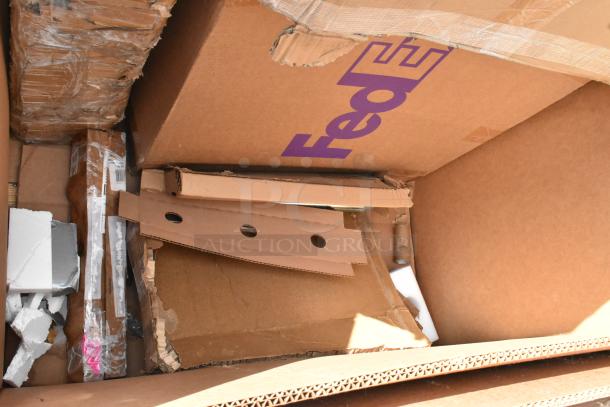 Cardboard box with FedEx label containing scratch and dent items including utility carts. Packaging materials visible.