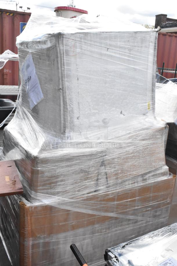 Lot of assorted items wrapped in clear plastic, marked "BRAND NEW SCRATCH AND DENT." Labels and markings visible on boxes.