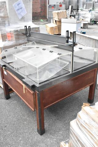 Wooden and metal dry merchandising station with clear acrylic display bins, sturdy frame, and adjustable shelving.