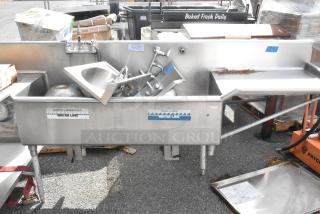 Stainless steel L-shaped 3-bay sink with dual drain boards and under shelf. Labels: "WATER LINE." Used, commercial condition.