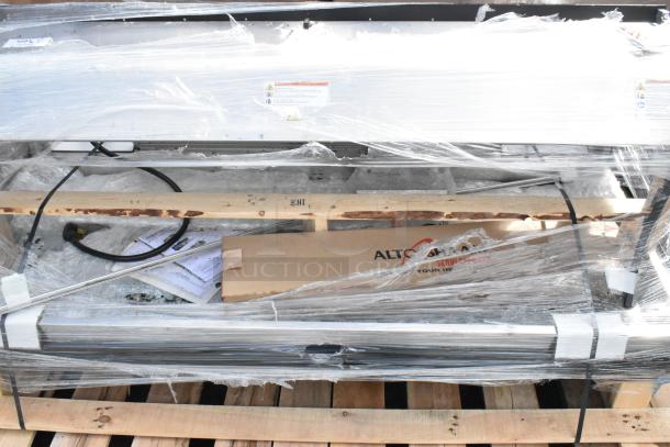 Brand new Alto Shaam metal commercial heated merchandiser, wrapped, with visible scratch and dent. Labels indicate make.