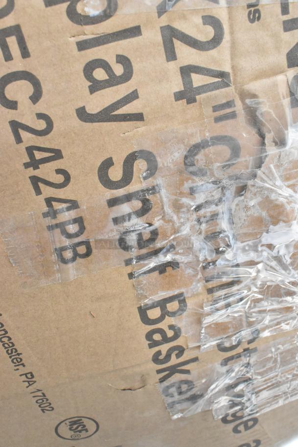 Cardboard packaging with visible text: "Regency 460EC2424PB 24" x 24" Chrome Storage Shelf Basket," showing product labeling under plastic wrap.