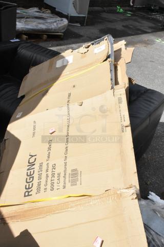 Cardboard packaging for a Regency 600T3072G 30" x 72" stainless steel work table, slightly damaged.