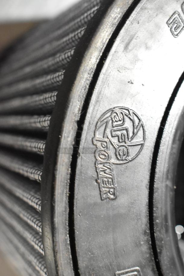 aFe Power automotive air filter with visible logo, cylindrical design, close-up view of the rubber rim.