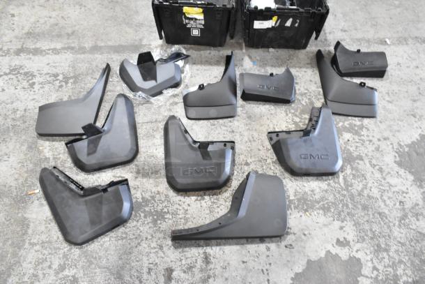 Black poly bin with multiple GMC-branded mudguards and parts. Parts appear unused and clean.