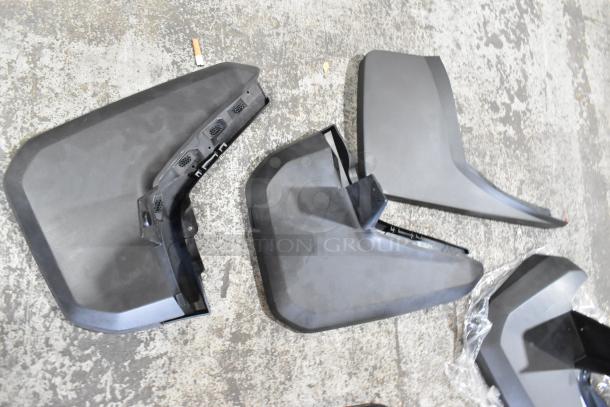 Box of various parts in two black poly bins on a concrete floor. Parts appear in fair condition with minor wear.