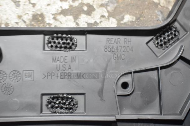 Box of parts in black poly bin showing a car part with "Made in U.S.A.", "REAR RH 85547204 GMC", and GM logo embossed.