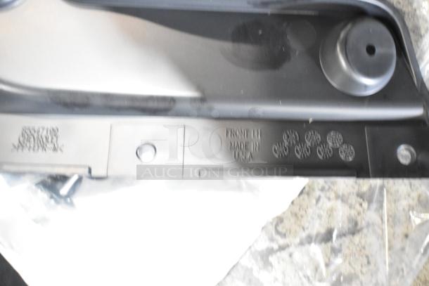 Box of parts in black poly bin, featuring a stamped marking "FRONT LH MADE IN USA." Parts look unused.