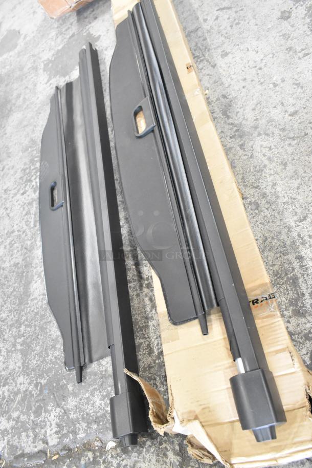 Three items including two black pull-down screens with handles on a concrete floor, in fair condition.