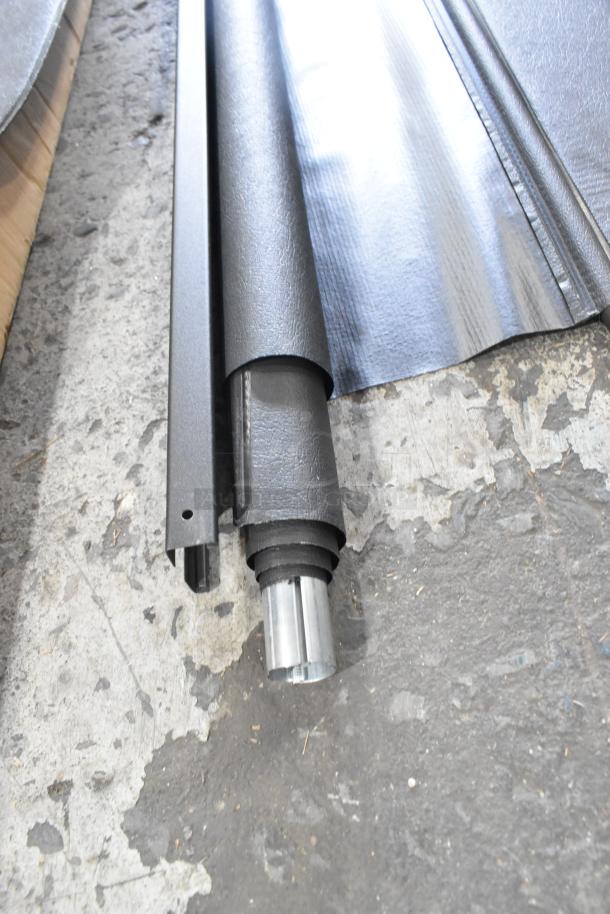 Alt text: "Two pull-down screens in black casing on a textured floor, part of a set of three various items."