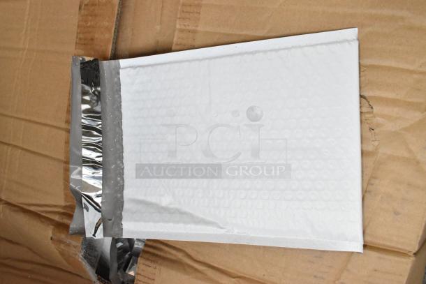 Brand new box of white bubble mailers on cardboard. Features silver adhesive strip. Perfect condition.