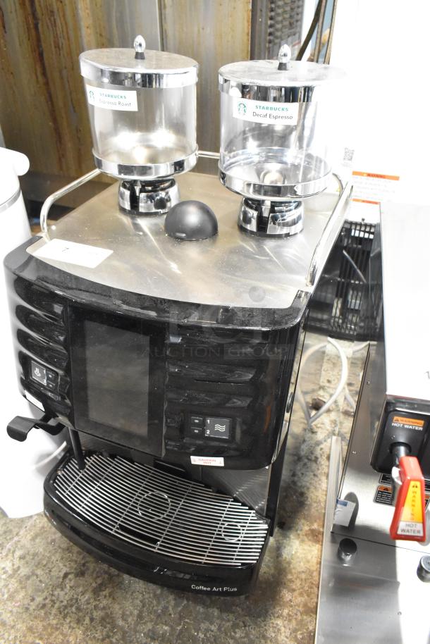Schaerer Coffee Art Plus commercial espresso machine with dual hoppers, black finish. Labels read "Starbucks Espresso Roast" and "Decaf Espresso." Electric, 120-208/240V.