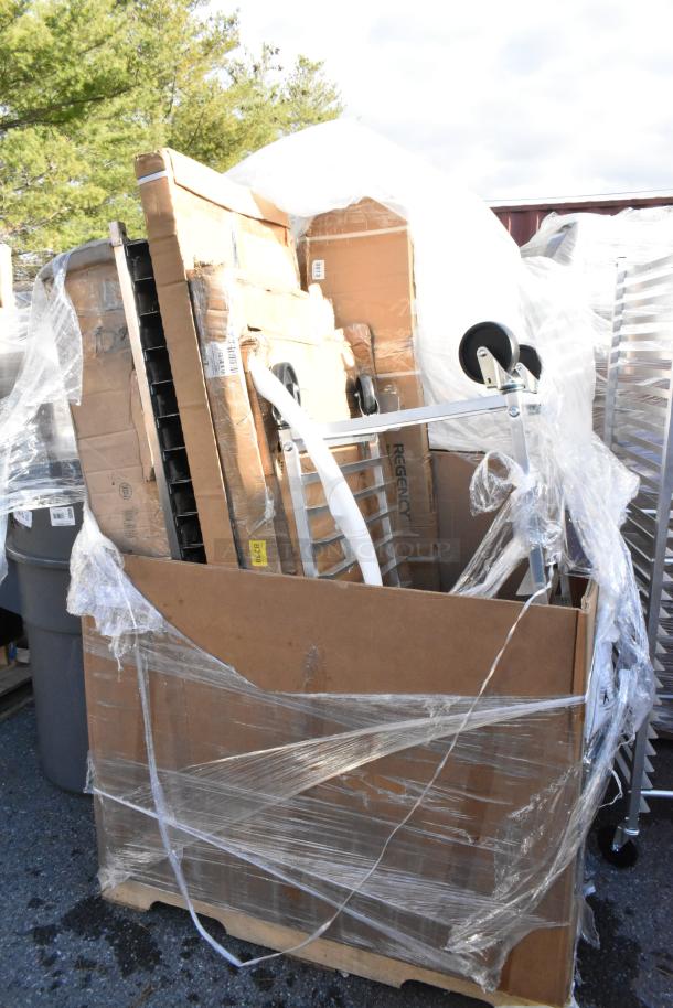 Brand new scratch and dent lot with pan rack, shelf, and tabletop. Items wrapped in plastic, visible Regency label.