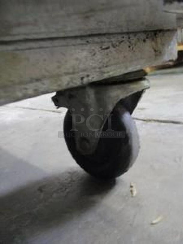 Caster wheel of Atosa MBF8507GR refrigerator, showing wear; part of 54" two-section reach-in model.