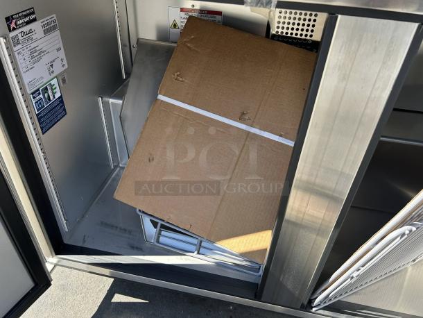 True TUC-48-C-HC undercounter refrigerator, stainless steel, like new, with open doors showing interior and label details.