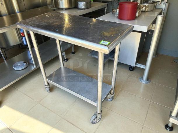 Stainless steel worktop table with rounded edges, casters, and lower shelf. Excellent condition, perfect for kitchen use.