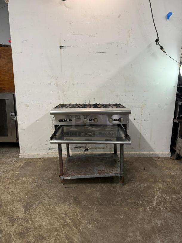 Commercial 36" 6-burner range with stainless steel finish, open shelf, slight wear, ideal for high-volume cooking settings.