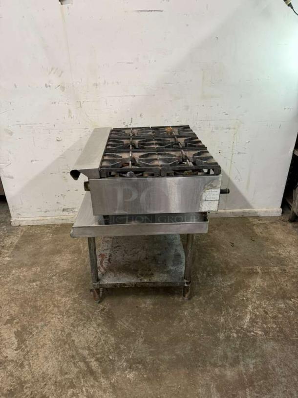 Commercial 36" 6 burner range with stainless steel body, showing wear. Suitable for restaurant use. No visible brand or model markings.