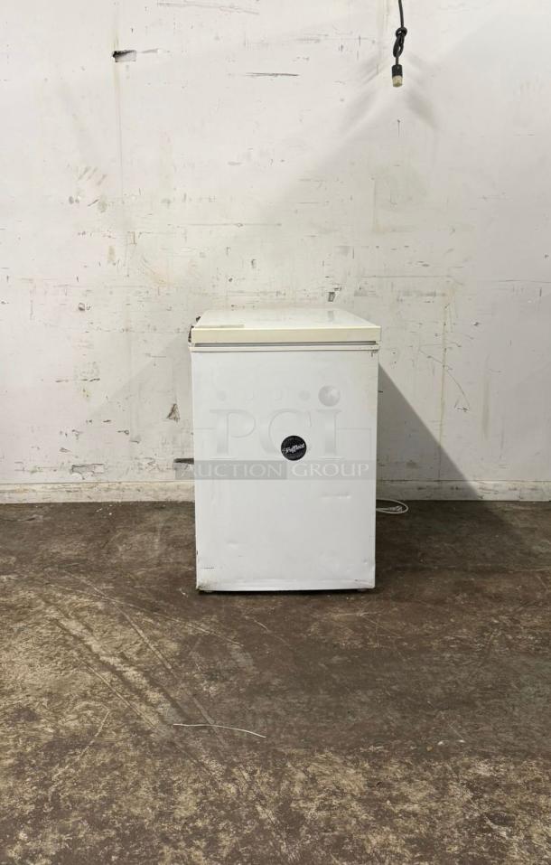 White deep freezer with minor wear, featuring a black logo label. Freestanding unit in functional condition.