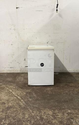White deep freezer with minor wear, featuring a black logo label. Freestanding unit in functional condition.