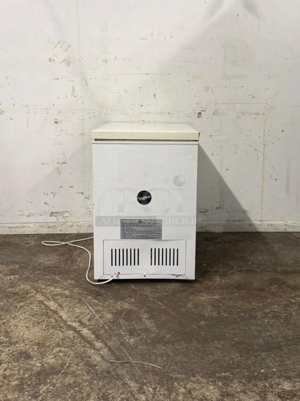 White deep freezer with lid and brand logo, used condition, power cord visible, manufacturer's label with safety instructions.