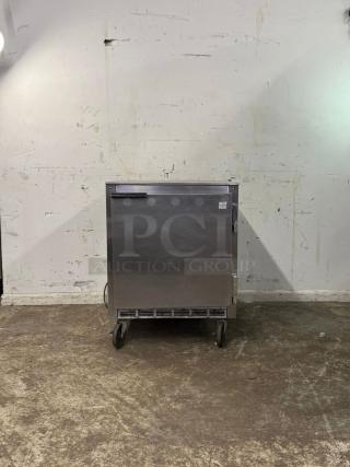 UNDER COUNTER 28" refrigerator, stainless steel, on wheels, visible label, appears in good condition.