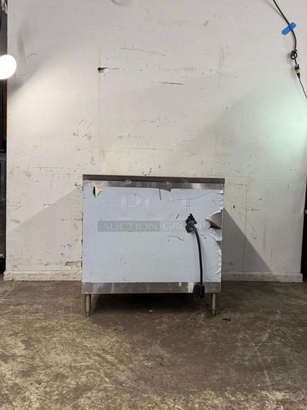 STEEM TABLE 3 WELL, commercial stainless steel table with electrical cord, signs of wear, durable construction.
