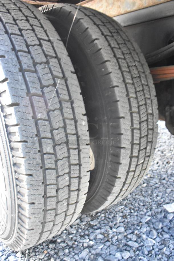 Dual rear tires of 2004 Izuzu Morgan Diesel Reefer Box Truck. Tires show moderate tread wear. Odometer: 215,769.