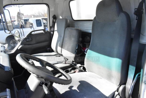 2004 Izuzu Morgan Diesel Reefer Box Truck cab interior. Features three gray seats, steering wheel, odometer at 215,769 miles.