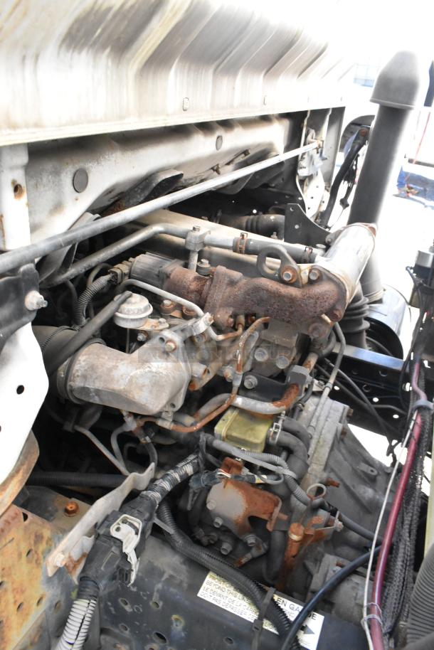 Engine compartment of a 2004 Isuzu Morgan Diesel Reefer Box Truck, showing rusted components and Carrier Transicold system.