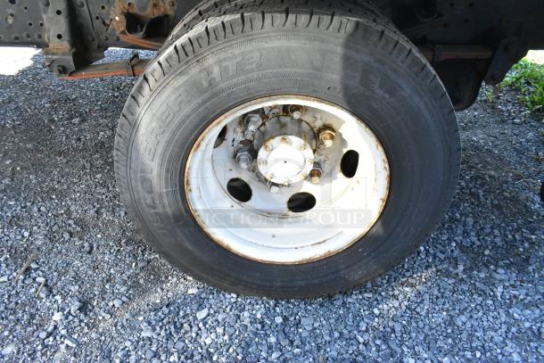 Tire of a 2004 Izuzu Morgan Diesel Reefer Box Truck, visible rust on rim, tire marked "Discoverer HT3." Odometer: 215,769.