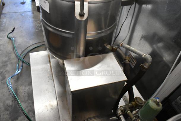 Groen TDB/7-40 stainless steel 10-gallon manual tilt steam kettle on stand, showing pipes and equipment connections.