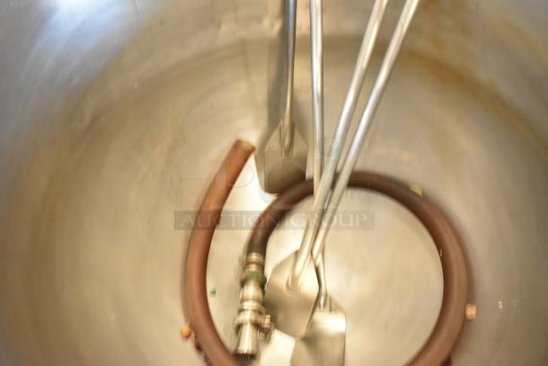 Stainless steel commercial floor-style kettle with agitator. Features include internal paddles and attached hose, in used condition.