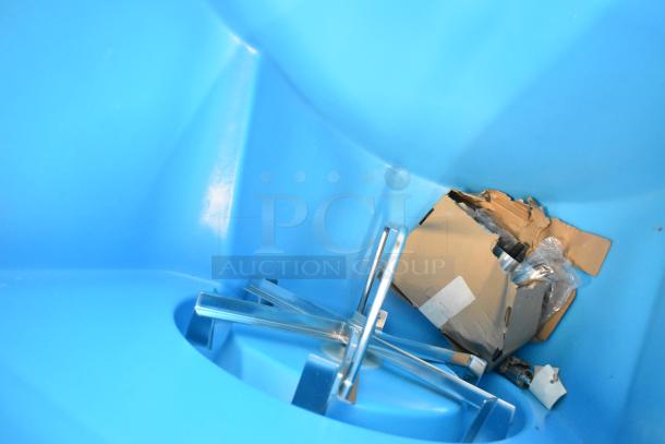 Interior of a Manitowoc SPA312-161 ice dispenser showing a blue compartment with metal components and packaging remnants.