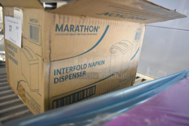 Brand new Marathon 6407124 Interfold Napkin Dispenser box with minor scratches, showing product illustrations and barcode.