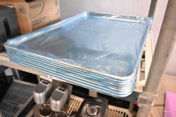 Stack of new aluminum bun pans in plastic wrap, 18"x26", 19-gauge, scratch and dent condition.