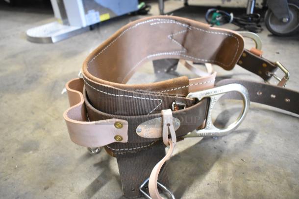 4 new Klein Tools 5268N23D body belts in scratch and dent condition, featuring durable leather and metal loops.