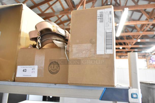 4 new Klein Tools 5268N23D body belts in boxes, slight scratches, tags indicate quantity and auction details.