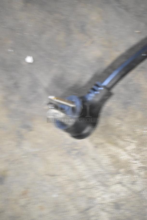 Blurry image of a power plug, likely related to a 2022 True T-19F-HC commercial freezer, 115 volts, 1 phase.