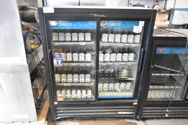 True GDM-41SL-60-LD metal commercial 2-door cooler with poly-coated racks, Pepsi branding, and price labels visible.